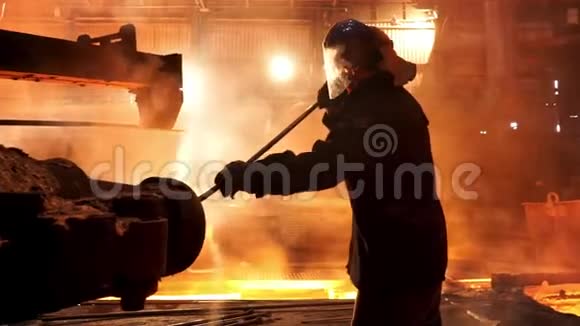 炼钢工人从冶金厂的感应坩埚熔炼炉中除渣工作辛苦视频的预览图