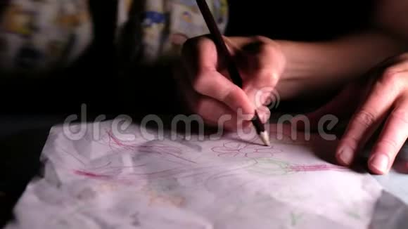 女人教孩子如何用铅笔在一张纸上画一朵花特写视频的预览图
