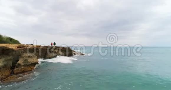 一对夫妇走在岩石海岸4k视频的预览图