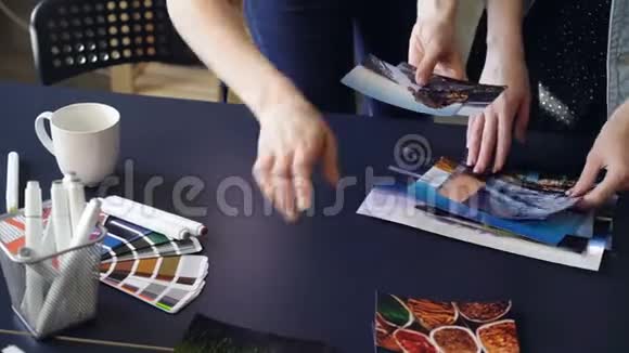女人手特写镜头把照片放在现代的桌子上分成几组调色板标记和视频的预览图