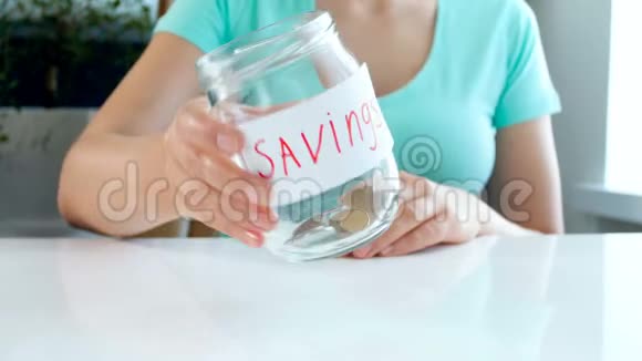 4k录像显示这位年轻女子在玻璃罐子里几乎没有硬币可供储蓄视频的预览图