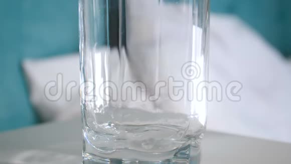 床头柜上装有冷水的玻璃杯的特写慢动作视频视频的预览图