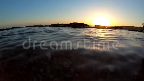 日落时靠近海岸的暗海面慢动作视频的预览图