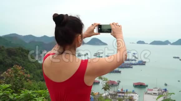 这位女士从岛的顶端拍摄一个海湾的照片这位女士要花很多钱去观看视频的预览图