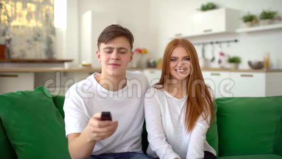 幸福的一对夫妇坐在沙发上在客厅里一起看电视视频的预览图