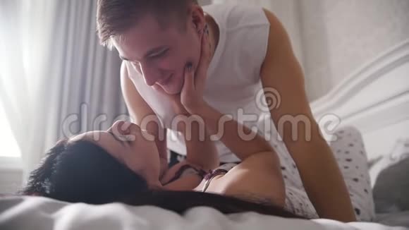 快乐的恋人在床上看着笑着抚摸着对方视频的预览图