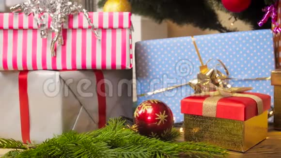 客厅圣诞树下的发光花环和礼品盒的特写镜头视频的预览图