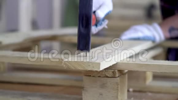 戴白手套的师傅用木制家具旧指甲的特写一只白手套的手把钉子钉进去视频的预览图