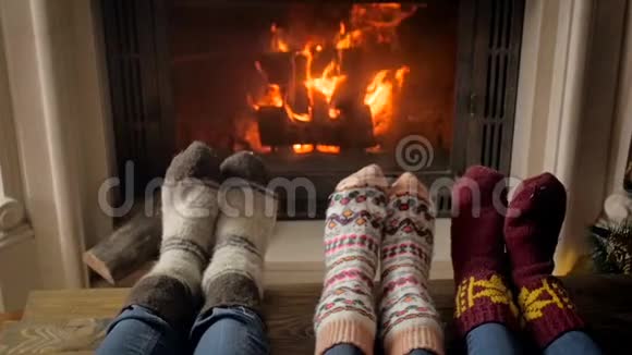 在壁炉旁的客厅里一家人穿着温暖的袜子慢动作视频视频的预览图