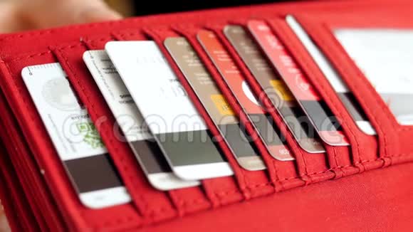 特写女性手从钱包中取出塑料信用卡的慢动作视频视频的预览图