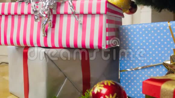 在客厅里摄像机沿着一大堆圣诞礼物和礼物缓缓移动的特写镜头视频的预览图