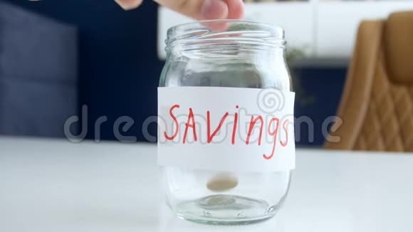 家庭储蓄的概念视频男人和女人在玻璃瓶里扔硬币视频的预览图