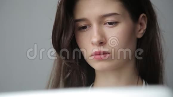 年轻女商人通过电脑工作灰色背景视频的预览图