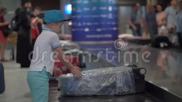 在机场的行李传送带上找他的手提箱视频的预览图