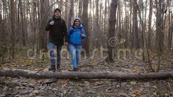 徒步旅行和背包概念秋日在森林里散步的一对小旅行者视频的预览图