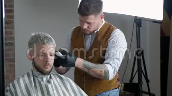 去理发理发店里坐在椅子上时一个留胡子的年轻人在理发店理发视频的预览图