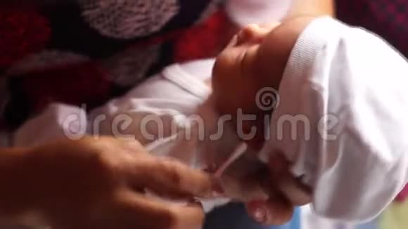 祖母用棉芽清洁刚出生的孙女的耳朵视频的预览图