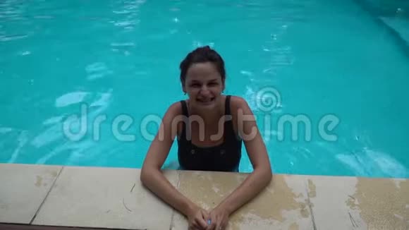 可爱的女人在游泳池里喝水视频的预览图