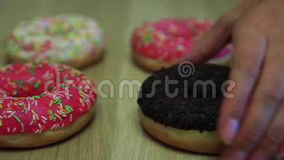 甜甜圈躺在桌子上被他们的手带走视频的预览图