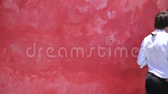 红墙背景上美丽的年轻夫妇波霍风格视频的预览图