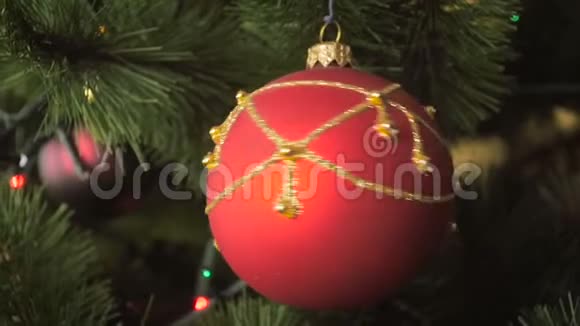 在装饰好的圣诞树上拍摄美丽的红宝贝旋转的慢镜头视频的预览图