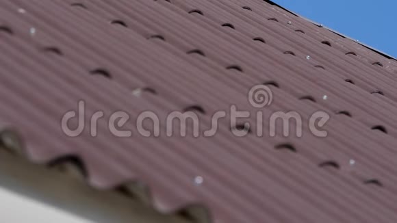 屋顶有灰色的屋顶瓦晴朗的蓝天阳光明媚的日子里有一些云瓷砖屋顶背景纹理视频的预览图
