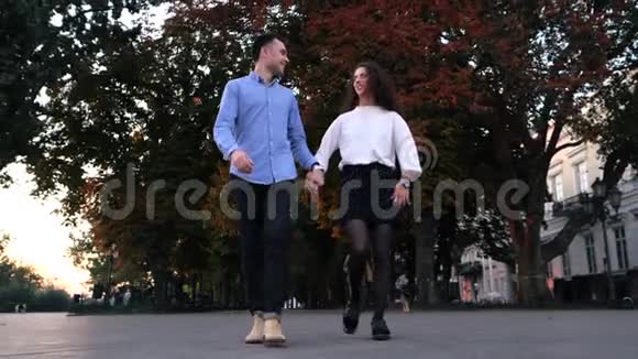 一对年轻的男女在秋城散步时尚快乐的一对或穿商务服装的学生牵手视频的预览图