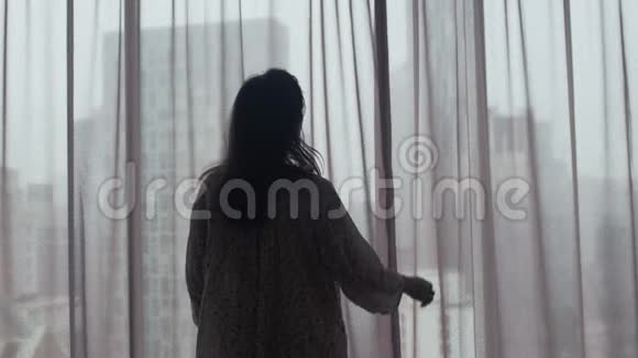 悲伤的被忽视的女孩肮脏的头发打开窗帘看在窗户上的柯班建筑在雨中3840x2160视频的预览图