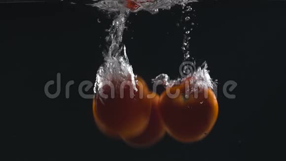 三个新鲜西红柿掉在水里有机食品素食营养沙拉视频的预览图