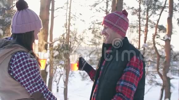 日落时分几个穿着冬装的年轻人在一片雪林中戴着覆盖着葡萄酒的酒杯视频的预览图