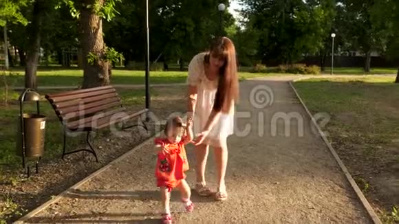孩子夏天在公园里学着走小路妈妈陪着孩子走视频的预览图