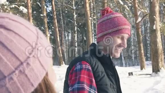 一个年轻人和一个女孩在冬日的森林里散步视频的预览图