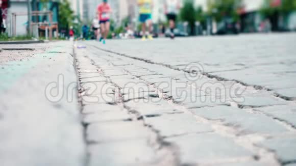 运动员沿着铺路石城市马拉松跑步者腿部特写体育比赛视频的预览图