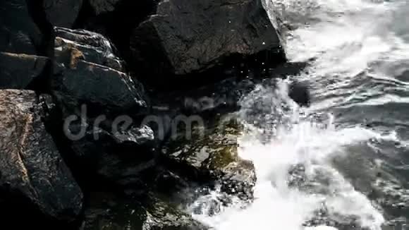 波浪撞击岩石慢动作关闭海浪直接溅向摄像机或观众的镜头视频的预览图