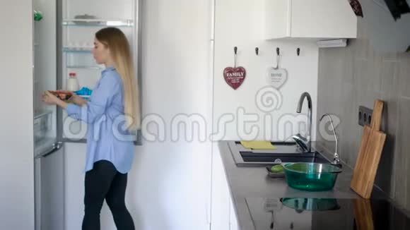 年轻漂亮的家庭主妇在厨房里准备烹饪原料视频的预览图