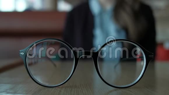 女人从桌子上拿眼镜衣服在自己身上视频的预览图