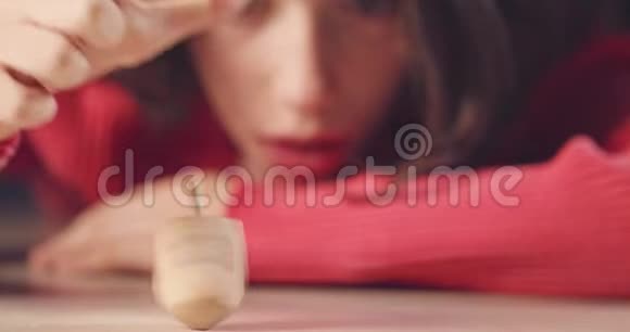 近距离拍摄一个女孩在地板上旋转一个哈努卡德雷德尔视频的预览图