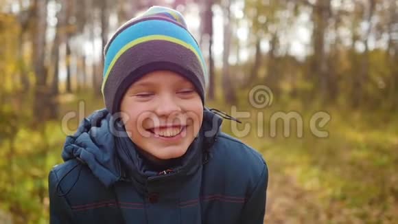 秋天公园里的少年笑着在松林里散步视频的预览图
