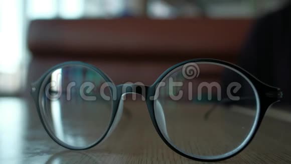 女人从桌子上拿眼镜衣服在自己身上视频的预览图