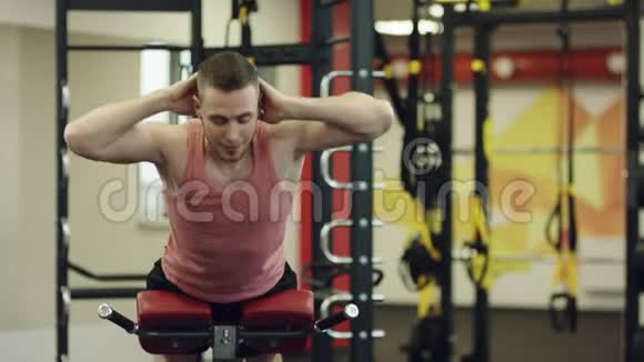 强壮的男人在健身房的长凳上做压力练习视频的预览图