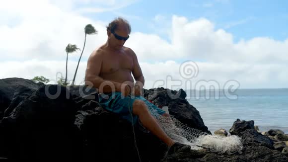 渔夫在海滩上拿着渔网视频的预览图