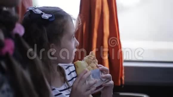 小女孩坐着旅游巴士吃着三明治视频的预览图