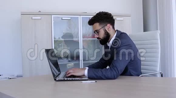 商人坐在办公室在笔记本电脑上打字视频的预览图