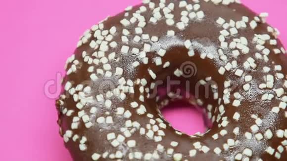 粉色背景下旋转巧克力甜甜圈饮食诱惑垃圾食品视频的预览图