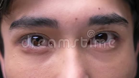 年轻迷人的亚洲男性眼睛直视镜头的特写镜头视频的预览图