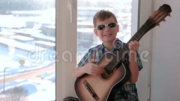 演奏乐器男孩弹吉他坐在窗台上唱歌视频的预览图