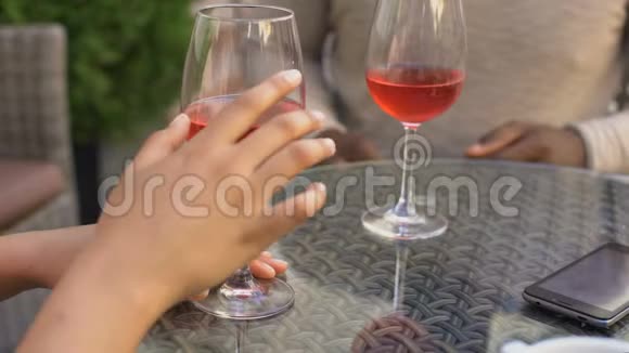 年轻男女牵着手喝着酒放松初次约会时调情视频的预览图