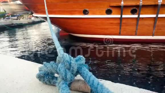 在港口停泊着一艘蓝色粗绳的大型老式木游艇的特写镜头视频的预览图