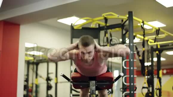 在健身房的长椅上做压力练习的人视频的预览图