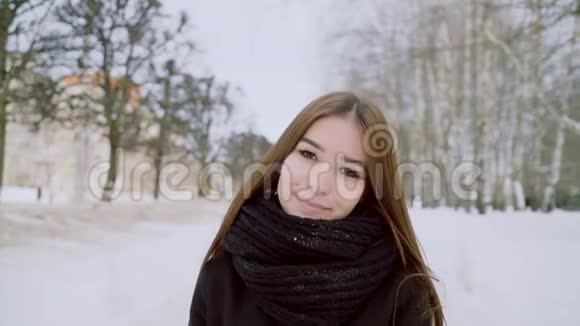 一个年轻女孩的冬天肖像那个女孩正对着照相机微笑快乐的黑发女人视频的预览图